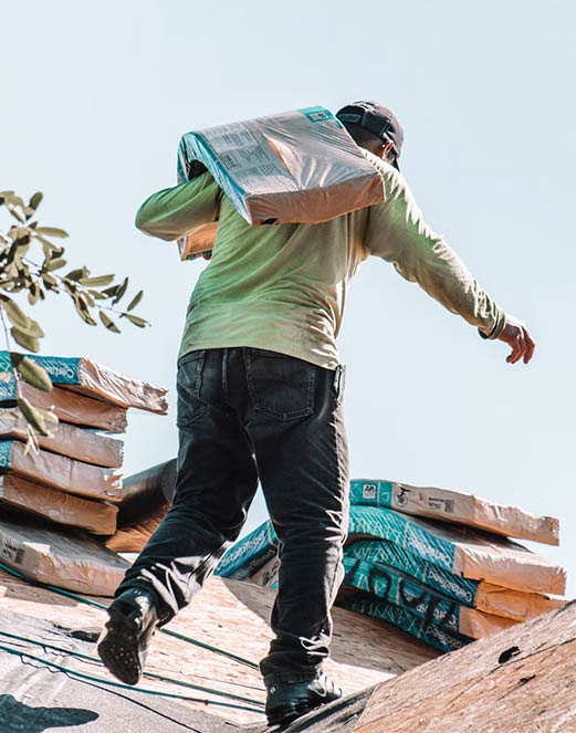 Roofer installing shingles